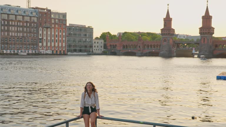 Woman walking in Berlin at sunset  near Oberbaumbrucke bridge