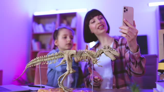 Young woman and little cute girl filming video of their scientific research.
