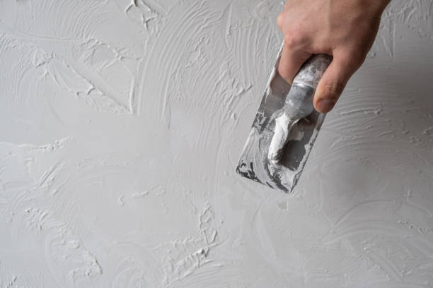 istock Applying decorative putty. White abstract texture of surface covered with putty 2130841308