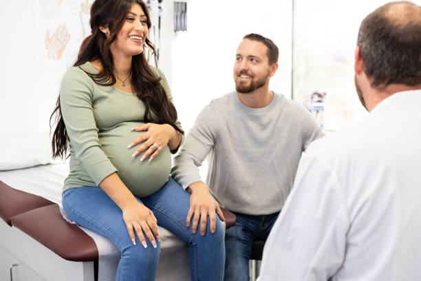 istock Happy young pregnant couple meet with unrecognizable obstetrician 2130870096