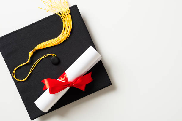 istock Graduation cap and diploma isolated on white background. Flat lay, top view. 2130872714
