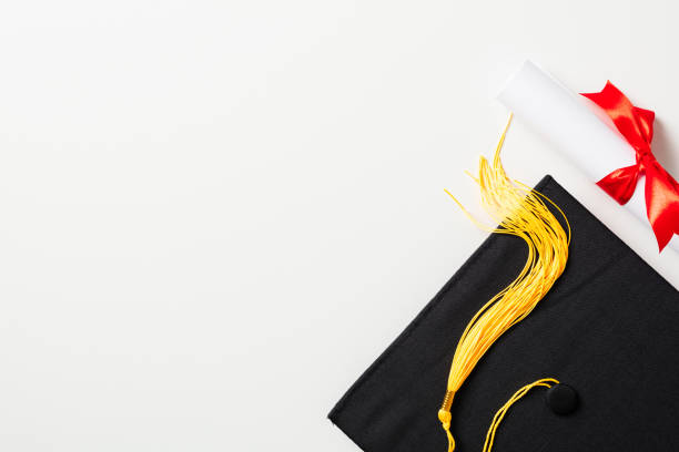 Graduation cap and diploma isolated on white background. Flat lay, top view.