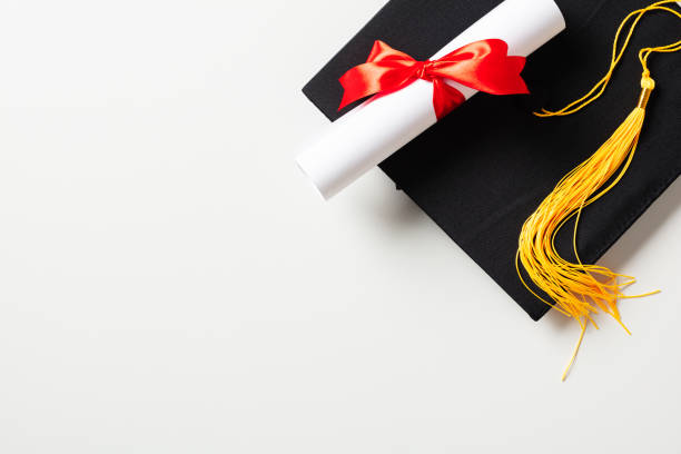 istock Graduation cap and diploma on white background. Flat lay, top view. 2130875371