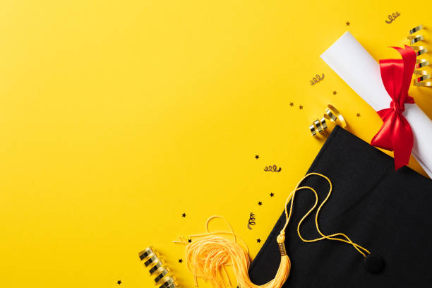 istock Graduation cap and diploma with gold glitter tinsel on yellow background. Flat lay, top view. 2130877451
