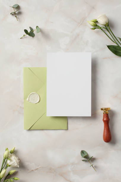 istock Wedding invitation mockup and olive envelope on stone background with flowers. Elegant wedding flat lay composition. Top view. 2130889911
