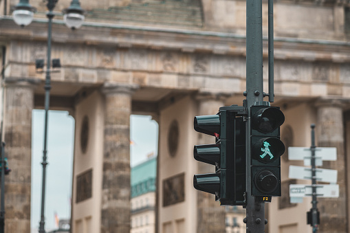 Famous red and green lights on pedestrian crossings in Berlin, Germany. Background is typical Berlin, Brandenburg gate. Green light is lit