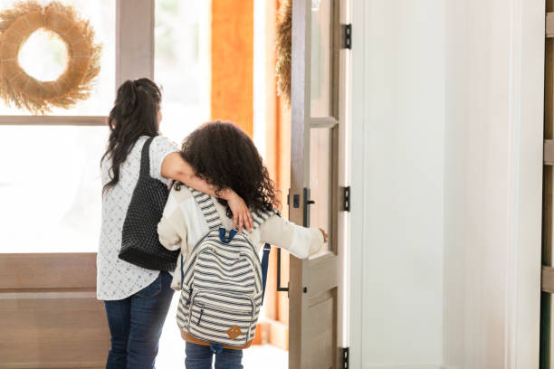 istock Unrecognizable young elementary age girl opens the door to leave for school 2130901237