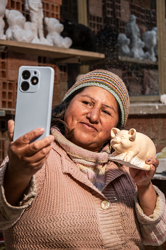 latin artisan working woman taking a selfie for her social networks - work concept