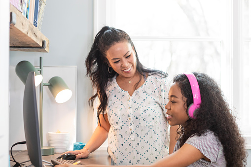 While working through her online math class, the young female adolescent asks her mom a question.