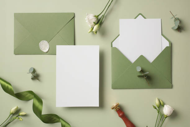 istock Wedding flat lay kit on green background. Wedding invitation card mockup, envelopes, wax seal stamp, green ribbon. flowers. Top view. 2130908243