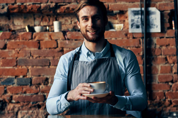 istock male waiter wearing apron coffee cup service lifestyle 2130923282