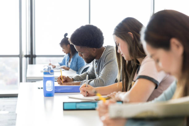 istock Diverse group of students diligently work on their exam 2130940422