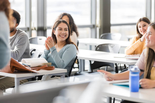 istock Diverse group of high school students smile and clap for their peer 2130940959