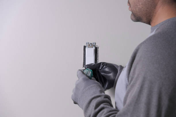 unrecognizable man working on a light switch unrecognizable man working on a light switch cable tester stock pictures, royalty-free photos & images