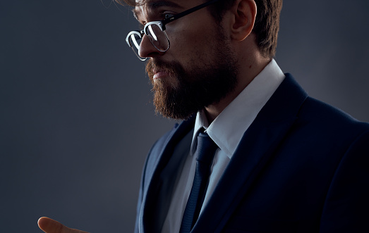 Handsome man with beard and glasses business model suit side view. High quality photo