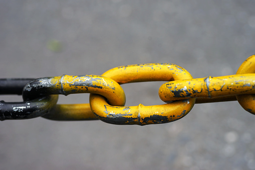 Close-up of a yellow metal chain with two connected links