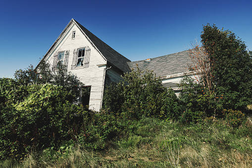 A rural farm house fades away with time.