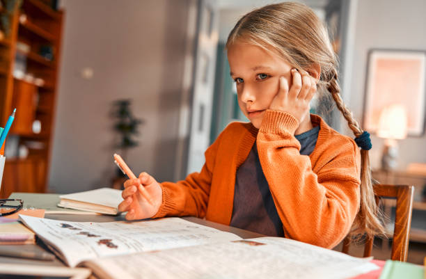 Remote educational system. Caucasian girl holding hand on cheek and getting ready for online class with pen in hand