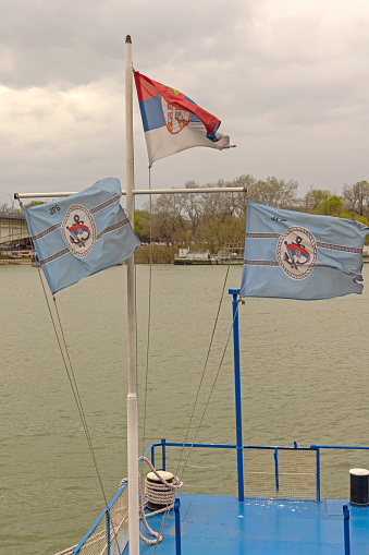 Belgrade, Serbia - March 11, 2024: Yugoslav River Shipping Company Jrb Flags at Ship Mast Cloudy Winter Day.