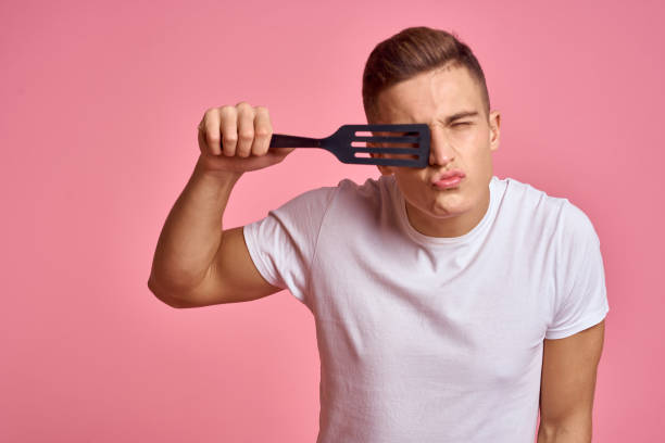 istock Man with kitchen tools on pink background spatula for cooking model cropped view 2131208021