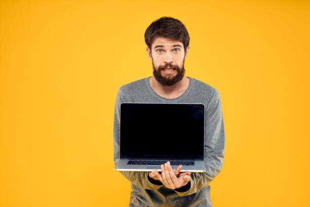 istock man with laptop wireless technology internet lifestyle work yellow isolated background 2131223609