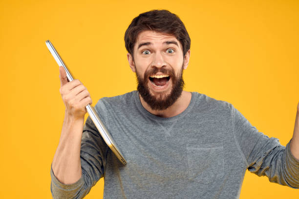 istock man with laptop wireless technology internet lifestyle work yellow isolated background 2131242748