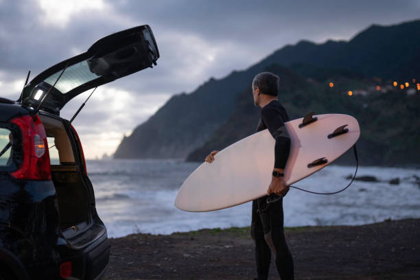 istock Surfing at dawn. Mature surfer driven to surf. 2131375657