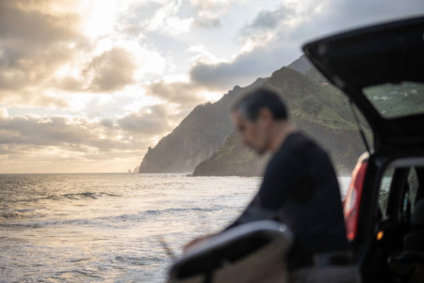 istock Surfing at sunrise. Surfer next to car with surfboard. 2131375677