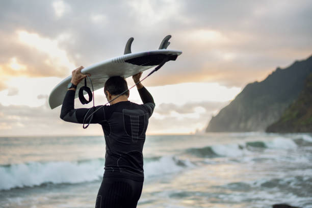 istock Surfing at sunset. Heading to the waves. 2131375679