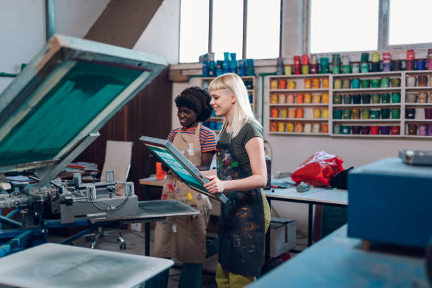 istock Print shop worker putting plate on machine and interracial supervisor watching 2131378976