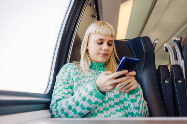 istock A traveler sitting in train and using her cellphone during journey. 2131379497