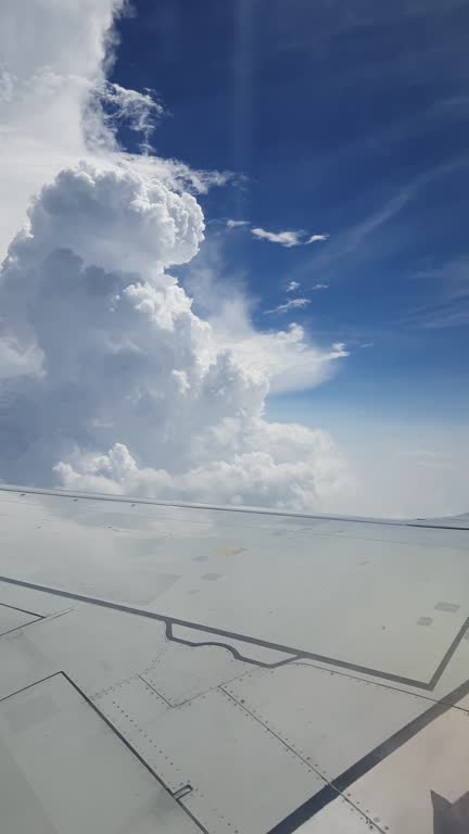 Cumulus clouds in the blue sky viewed from window plane