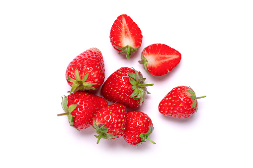 Fresh red strawberries with half slice isolated on white background, top view, flat lay.