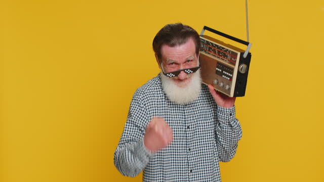 Happy old man listen music on retro tape record player, disco dancing, fan of vintage technologies