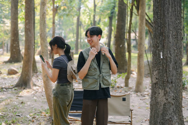 istock Asian couple clinking coffee mug together at camp side, They feeling relaxed and refreshing while camping in the nature. Recreation 2131490177