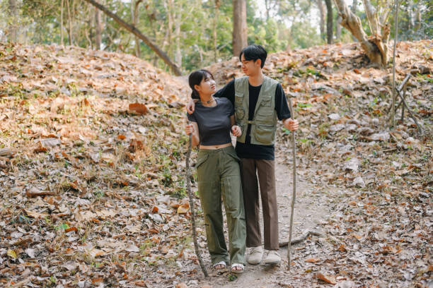 istock Asian couple clinking coffee mug together at camp side, They feeling relaxed and refreshing while camping in the nature. Recreation 2131490213