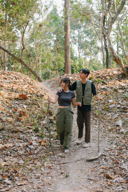 istock Asian couple clinking coffee mug together at camp side, They feeling relaxed and refreshing while camping in the nature. Recreation 2131490215