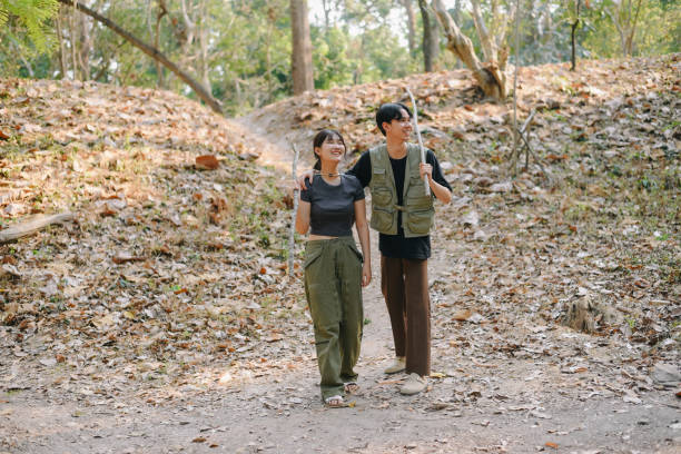 istock Asian couple clinking coffee mug together at camp side, They feeling relaxed and refreshing while camping in the nature. Recreation 2131490738