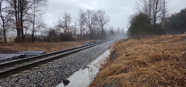 Railroad tracks dissappear in the fog dark cloudy day