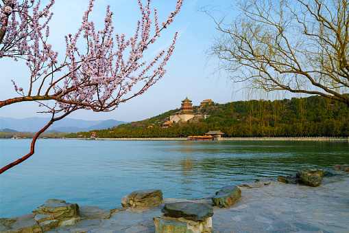 The spring is coming. And the Summer Palace in Beijing, China demonstrates a refreshing scenery with sprouting willows and blooming peach trees. In combination with calming water of Kunming Lake, it shows the traditional Chinese beauty.
