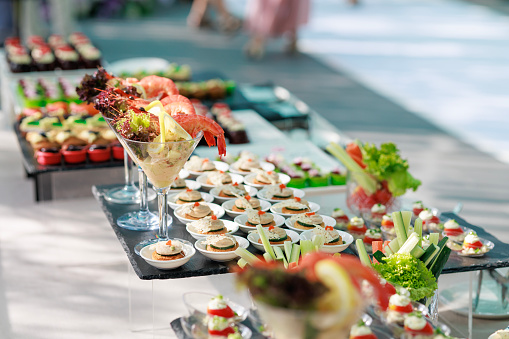 Various sweet desserts, appetizers, and finger foods are arranged on a buffet table, ready for party guests to enjoy.