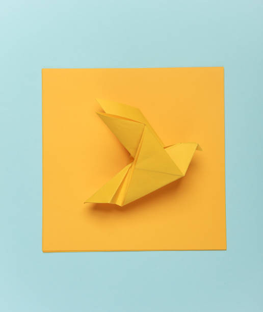 istock Yellow origami dove on a blue background 2131795185
