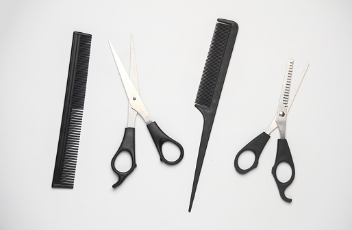 Scissors and combs for haircuts on a white background