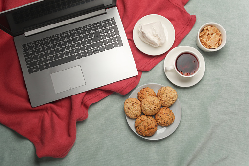 Laptop and breakfast in bed. Top view