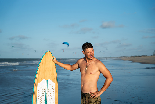 Male holding surfboard and having fun in beach in Brazil