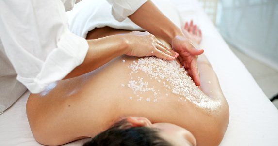 Skincare, relax and woman with salt for massage, natural exfoliate or body scrub at luxury spa. Masseuse, female person and peace at hotel with detox treatment, dermatology and self care for wellness