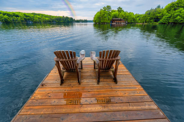 istock Adirondack Chairs on Wet Pier with Rainbow 2131807462