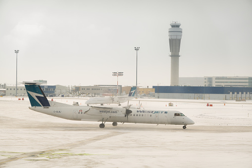 Calgary, Alberta, Canada. Mar 22, 2024. A Westjet at the Calgary International Airport plane during winter.