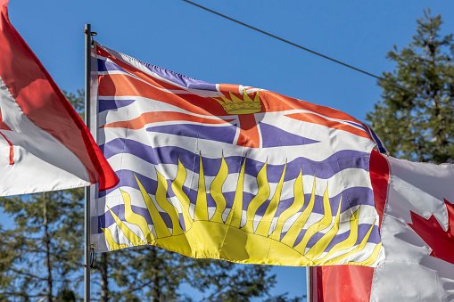 Vancouver, British Columbia, Canada. Mar 25, 2024. The flag of British Columbia, at the top of the flag is a rendition of the Royal Union Flag, defaced in the centre by a crown, and with a setting sun