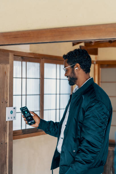 istock Mid adult man using a multilingual audio guide smartphone app at a Japanese shrine 2131898499